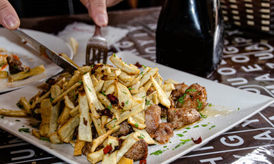 Carne de fiesta con patatas fritas en un guachinche