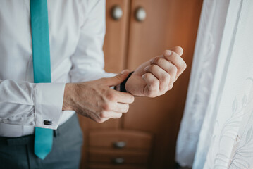 Young handsome man in classic suit. Young businessman puts on suit and prepares for a meeting.