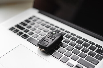 Laptop keyboard with car key on it. Car online services, rental or buying new auto
