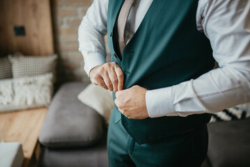 Young handsome man in classic suit. Young businessman puts on suit and prepares for a meeting.