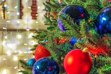 Close up of balls on christmas tree. Bokeh garlands in the background. New Year concept.