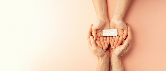 Pregnancy test kit. Female hand hold positive pregnant test with silk ribbon on pink banner background. Medical healthcare gynecological, pregnancy fertility maternity people concept.