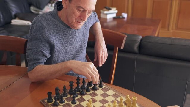 Brain training for senior citizens. Man playing chess with son on father's day