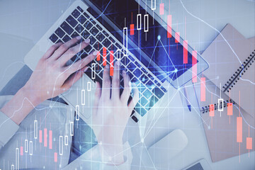 Double exposure of woman hands working on computer and forex graph hologram drawing. Top View. Financial analysis concept.