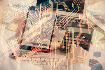 Double exposure of man's hands holding and using a digital device and tech theme hologram drawing. Technology concept.