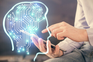 Double exposure of man's hand holding and using a digital device and brain hologram drawing. Data concept.