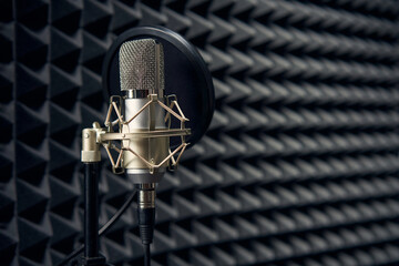 Studio chrome microphone on acoustic foam panel background, shallow depth of field