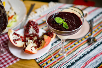 a cup of coffee on a table in a coffe shop in a beige mug . coffee with pomegranat, tea, restaurant, enjoy the taste dessert, cake, pastry, drink coffee, coffee to go,