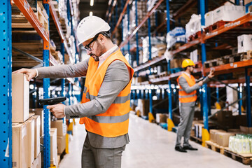 Supervisors using scanner to read bar code on goods package at warehouse.