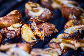 close up with brown champignon mushrooms on the grill.