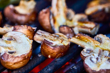 close up with brown champignon mushrooms on the grill.