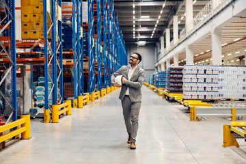 Obraz premium A proud warehouse owner walking around warehouse and looking up at delivery.