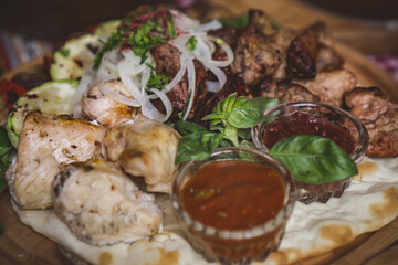 The richly laid table dishes of Georgian cuisine, lots of delicious food,wine,fruits and roasted meat