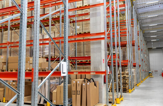 logistic, storage, shipment and industry concept - cargo storing at warehouse shelves