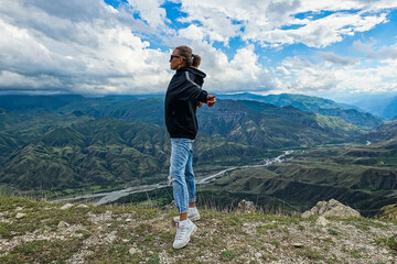 A girl on the background of a breathtaking view of the mountains in Dagestan, Caucasus. Russia 2021