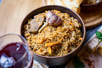 The concept of oriental cuisine. Homemade georgian Uzbek pilaf or plov from lamb served in cast...