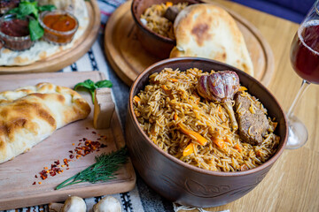 The concept of oriental cuisine. Homemade georgian Uzbek pilaf or plov from lamb served in cast iron cookware. Copy space.