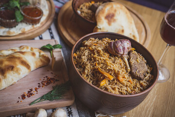 The concept of oriental cuisine. Homemade georgian Uzbek pilaf or plov from lamb served in cast...