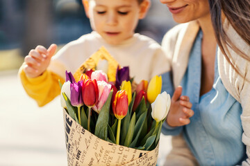 A boy and mother with flowers on mother's day.