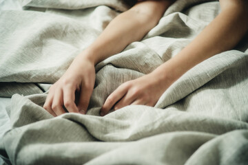 Obraz na płótnie Canvas hands on bed linen close-up