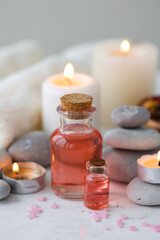Concept of spa treatment in salon. Natural organic oil, towel, candles as decor. Atmosphere of relax, serenity and pleasure. Anti-stress and detox procedure. Luxury lifestyle. White wooden background