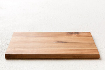 Perspective view of wooden cutting board on cement background. Empty space for your design