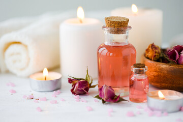 Concept of spa treatment in salon. Natural organic oil, towel, candles as decor. Atmosphere of...