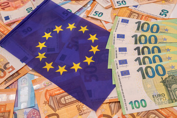 beautiful colored new euro banknotes on which lies the blue euro flag