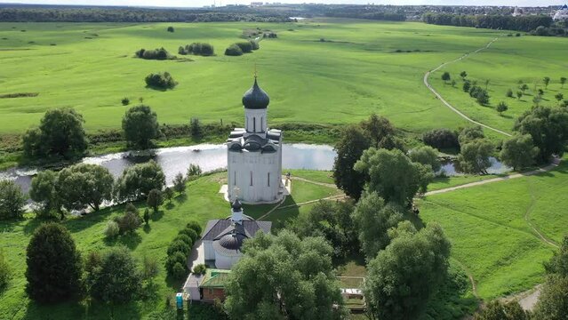 Aerial view of the ancient white-stone Church of the Intercession on the Nerl on a summer day, which is a historical monument and one of the most unique temples in Russia, Vladimir region.