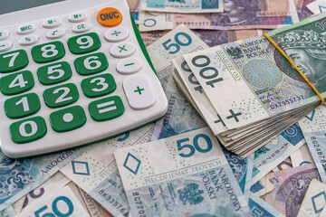 beautiful  Polish zloty banknotes beautifully scattered on the table next to the calculator.