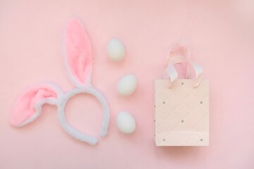 Pink bag, bunny headband and willow branches on a pink background.The concept of Easter, shopping for Easter.