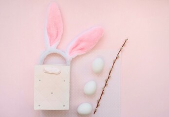 Pink bag, bunny headband and willow branches on a pink background.The concept of Easter, shopping for Easter.