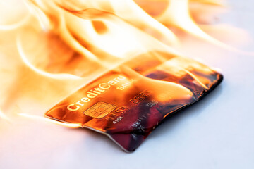 Bank credit card in flames on black background. Concepts of collapse of financial markets and the...