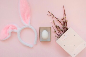 Pink bag, bunny headband and willow branches on a pink background.The concept of Easter, shopping for Easter.
