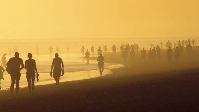 People in contre-jour light at the beach. Maspolomas beach on Canary island. Beach siesta at the Atlantic ocean. Canary island resort. Canary islands, Spain.