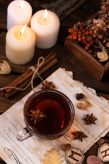 Wooden runes are lying on the table among the papers with notes. There is a mug of tea next to it. Astrology and esotericism.