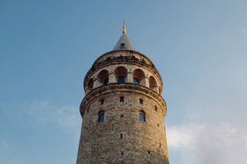 Fototapeta na wymiar Galata tower, a view of Galata Tower taken against a blue sky, visitor peoples on top of the tower are taking pictures, historical Istanbul and an architectural work that should definitely be seen.