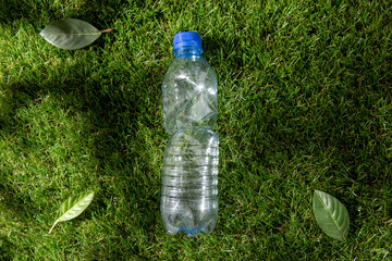 recycling, environment and ecology concept - close up of empty used crashed plastic water bottle on...