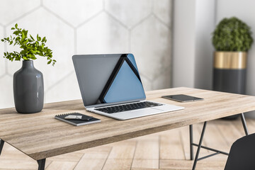 Sunny stylish home workspace with eco interior design: grey glossy clay pot with flowers, laptop, smartphone and digital tablet on natural wooden table and wooden floor, close up. 3D rendering