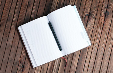 Fototapeta premium Open notepad and pen on wood background 