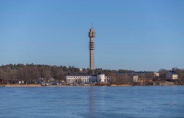 Fototapeta na wymiar Panorama view, the frozen bay Djurgårdsviken with museums and the tele tower Kaknästornet a sunny winter day in Stockholm