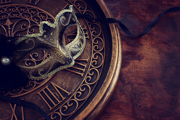 Photo of black with gold elegant Venetian mask over grunge background