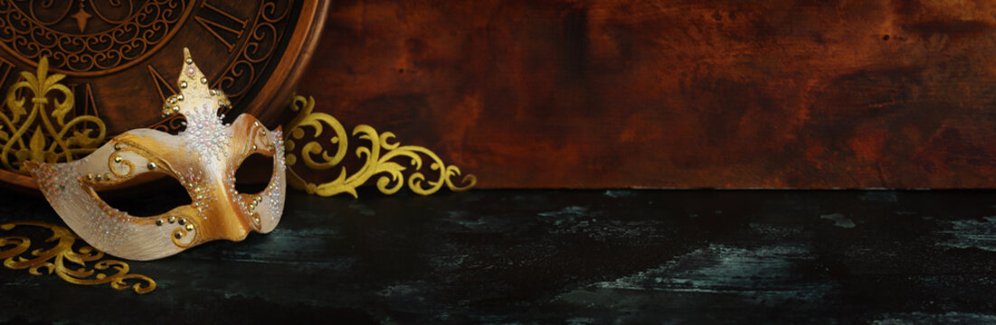 Photo of black with gold elegant Venetian mask over grunge background
