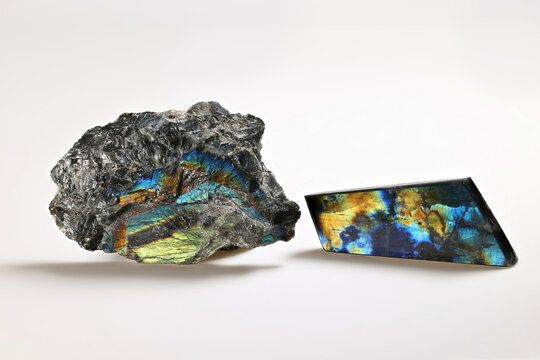 Uncut rough crystals and polished slab of colorful spectrolite mineral, lapidary gemstone from Finland