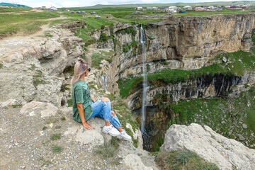 Girl on the background of Tobot waterfall, Khunzakh waterfalls, Dagestan Russia 2021