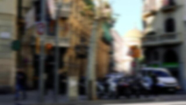 Defocused Blur View Of City Center Of Barcelona With Tall Buildings And Silhouettes Of People Cars Vans On A Busy Day