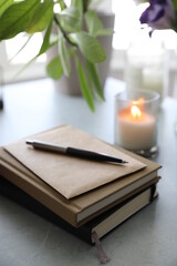 Notebooks, flowers and a candle on the table