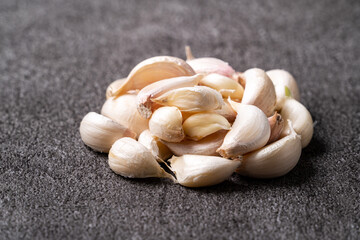 Fresh garlic cloves on black table background.