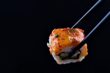 sushi with black chopsticks on black background