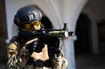 Caucasian woman in a protective suit with a machine gun. Female military man in camouflage uniform...